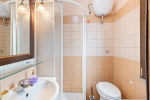 a bathroom with a shower and a sink and a toilet at Villa Anna con giardino in Flussio