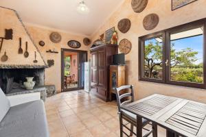 a kitchen with a table and a fireplace at Villa Anna con giardino in Flussio