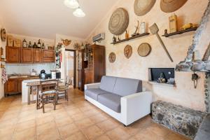 a living room with a couch and a kitchen at Villa Anna con giardino in Flussio +18 photos