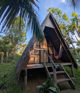 a thatch roofed house with a porch and stairs at Firefly Treehouse Cafe and Bar in Ytaya +19 photos