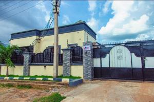 a large building with a gate and a garage at Seven Hills Suites in Makurdu +2 photos