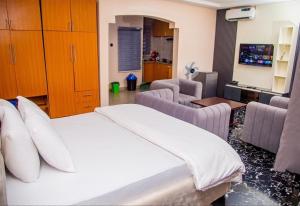 a bedroom with a bed and two chairs and a table at Seven Hills Suites in Makurdu