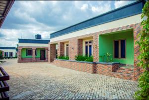 a brick building with green and white at Seven Hills Suites in Makurdu