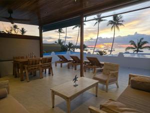 a living room with a table and chairs on the beach at Casa By The Sea in Bangrak Beach