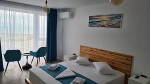 a bedroom with a bed and a large window at Ella Apart Hotel in Constanţa