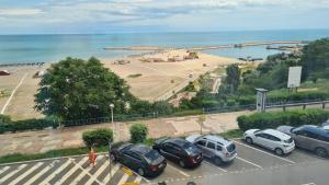 a group of cars parked in a parking lot next to a beach at Ella Apart Hotel in Constanţa