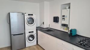 a kitchen with a refrigerator and a washer and dryer at Ella Apart Hotel in Constanţa
