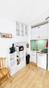 a kitchen with white cabinets and a sink at Cozy studio in La Foux +18 photos