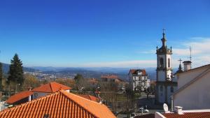 a view of a town with a clock tower at Abrigo da Estrela in Covilhã