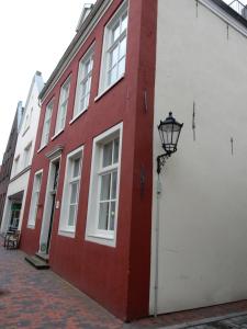 a red and white building with a street light next to it at Altstadt-Glück Leer Ferienwohnung in Leer