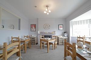 a dining room with wooden tables and chairs at Sunrise Guest House in Bude