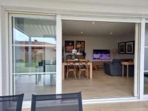 a dining room and living room with sliding glass doors at Bernard in Soustons
