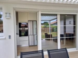 a sliding glass door of a house with two chairs at Bernard in Soustons