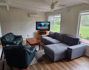 a living room with a couch and a tv at Prom Coast Residence in Fish Creek
