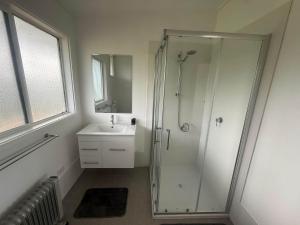 a bathroom with a shower and a sink at Prom Coast Residence in Fish Creek +5 photos