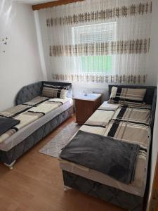 two beds in a room with a window at Ferienwohnung Sabina in Bosanska Krupa