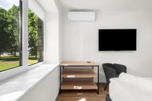 a living room with a desk and a tv at K4 Jonava Rooms in Jonava