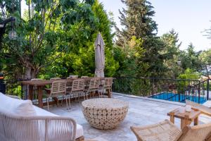a patio with a table and chairs and an umbrella at Büyükada Apart Hotel in Adalar +212 photos