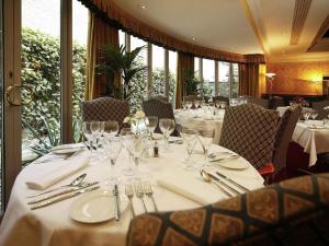 a dining room with a table with glasses and silverware at Mercure York Fairfield Manor Hotel in York