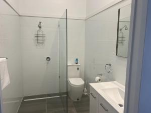 a white bathroom with a toilet and a sink at Branxholm Hotel in Branxholm