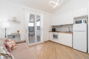 a living room with a couch and a kitchen at Casa Mare Vecchio in Avola