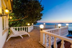 a white bench sitting on a balcony looking out at the ocean at Hotel Pansion Villa Antonio in Orebić +80 photos