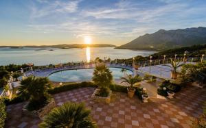 a resort with a pool and a view of the water at Hotel Pansion Villa Antonio in Orebić