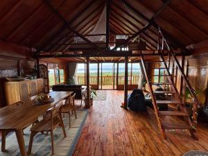 a room with a wooden table and a wooden floor at Lakey Views Sumbawa in Huu