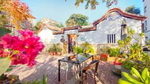 a house with a table and flowers in front of it at Naya"s Homestay in Jincheng