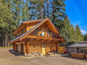 a log cabin with a balcony on top of it at Aspen Cabin | Log Home | Hot Tub, Wood stove in Packwood