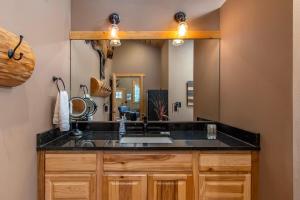 a bathroom with a sink and a large mirror at Aspen Cabin | Log Home | Hot Tub, Wood stove in Packwood +120 photos