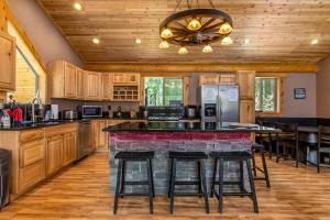 a kitchen with wooden cabinets and a bar with stools at Aspen Cabin | Log Home | Hot Tub, Wood stove in Packwood
