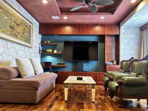 a living room with a couch and a flat screen tv at Hotel Palm Royal Resort Kokusai Street in Naha