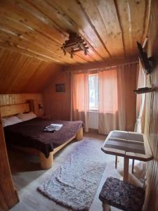 a bedroom with a bed and a wooden ceiling at Садиба Сонячний дім in Pilipets