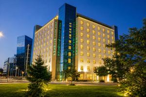 a large building with a tree in front of it at Vitosha Park Hotel - Free Pool & Gym in Sofia