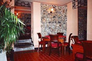 un restaurante con mesa, sillas y pared de piedra en Locanda Dal Moccia, en La Spezia