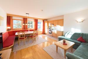 ein Wohnzimmer mit einem Sofa und einem Tisch in der Unterkunft Aparthaus Sonnenhof in Alpbach