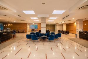 a lobby with blue chairs and a table in it at Vitosha Park Hotel - Free Pool & Gym in Sofia +56 photos