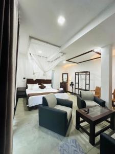 a hotel room with a bed and a couch and a table at Peak Blooms Ella in Ella