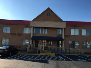 トムソンにあるDays Inn by Wyndham Thomsonの駐車場に車が停まっている建物