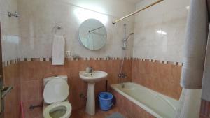 a bathroom with a toilet and a sink and a mirror at Boudha Breeze Suites 3bhk in Kathmandu +39 photos