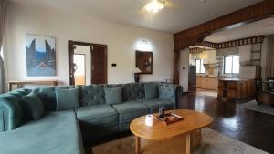 a living room with a blue couch and a table at Boudha Breeze Suites 3bhk in Kathmandu