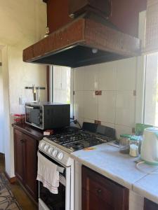 a kitchen with a stove and a microwave at Rest has a name: Munay in Tafí del Valle