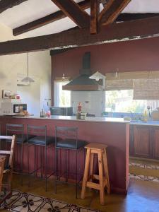 a kitchen with a bar with stools and a counter top at Rest has a name: Munay in Tafí del Valle