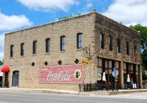 a brick building with a cocacola sign on it at Upstairs Inn in Hico