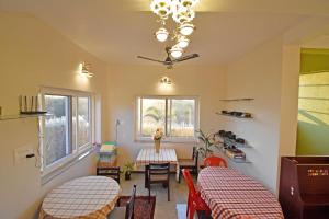 a room with two beds and a table and chairs at La Casa d'Auroville in Auroville +75 photos