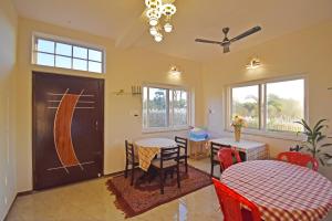 a dining room with two tables and a table and chairs at La Casa d'Auroville in Auroville
