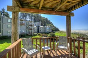 two chairs on a deck with a view of condos at Little Creek Cove Beach Resort in Newport