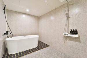 a bathroom with a bath tub and a shower at Jamsil Tomgi Hotel in Seoul +43 photos