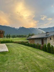 a yard with a house and mountains in the background at Bansko Lux Villas for Ski & Chill by Top Kvartiri Ltd in Razlog
